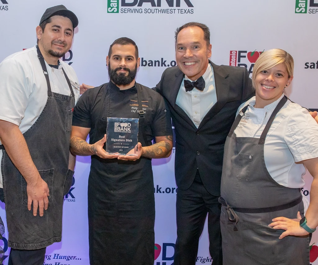 La Cantera event chefs receiving award from Food Bank CEO Eric Cooper.